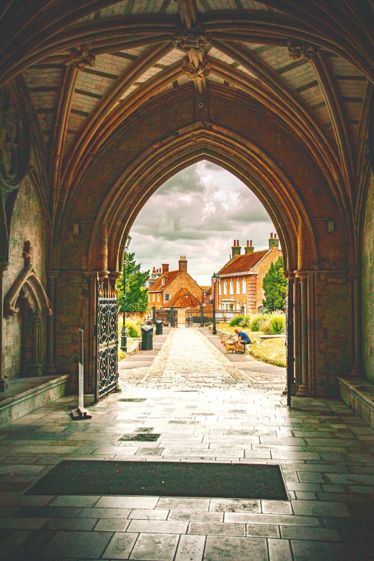 Christchurch Priory archway looking out toward red-brick townhouses